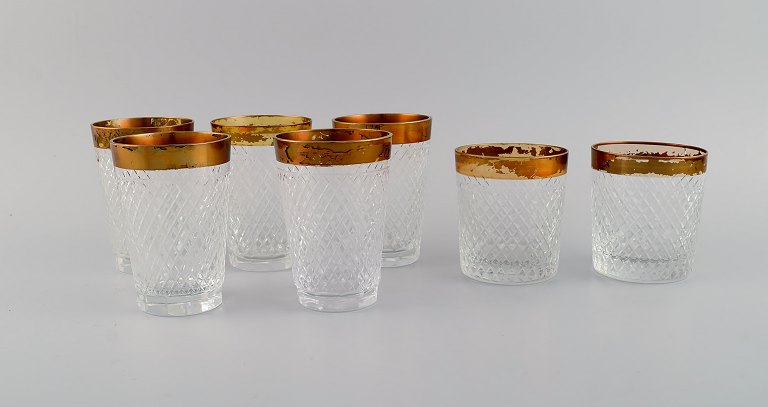 Seven drinking glasses in mouth-blown crystal glass with gold edge. France, 1930s.