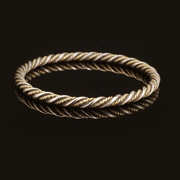 Georg Jensen armring. Georg Jensen snoet armring i sterlingsølv og 18kt guld. #17A. Stemplet Georg Jensen. Indv. diameter: 6,1cm