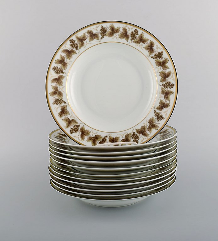 12 Limoges dybe tallerkener i porcelæn med håndmalede vindrueranker og gulddekoration. 1930/40
