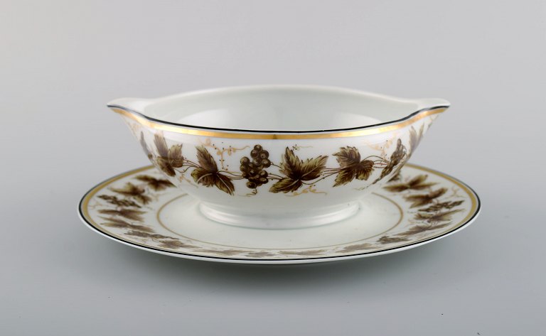 Limoges sovsekande på stand i porcelæn med håndmalede vindrueranker og gulddekoration. 1930/40