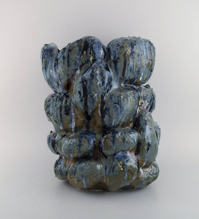 Christina Muff, dansk samtidskeramiker (f. 1971). Stor skulpturvase i stentøj. Vasen er glaseret med grå og blå glasurer på en brun bund. Vasen er en del af 