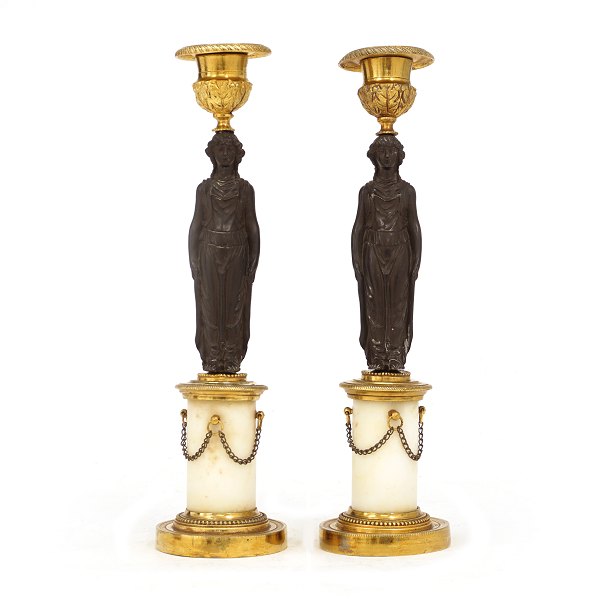 Et par lueforguyldte bronzestager delvist sortpatinerede med marmorsokler. Frankrig ca. år 1830. H: 28cm