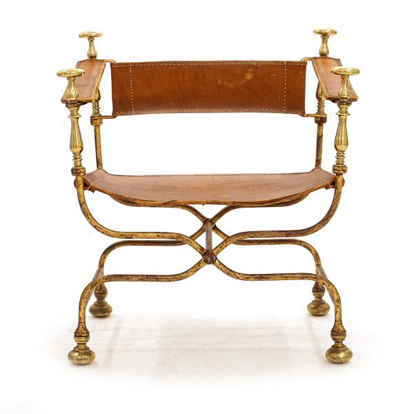 Ialiensk armstol med stel i forgyldt metal med messingmontering. Sæde og ryglæn i kernelæder. Italien ca. år 1950. H: 73cm. B: 65cm. D: 45cm. Hs: 37cm