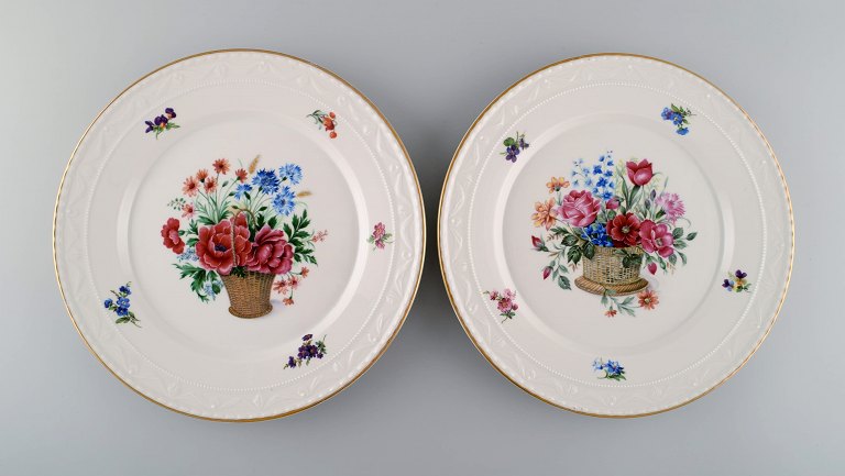KPM, Berlin. To antikke tallerkener i porcelæn med håndmalede blomsterkurve og guldkant. Tidligt 1900-tallet.
