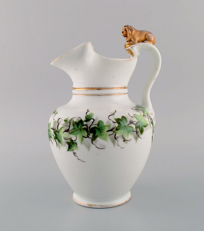Antique Bing & Grøndahl chocolate jug in porcelain modeled with a lion on the handle. Hand-painted flowers and gold decoration. 1870s.