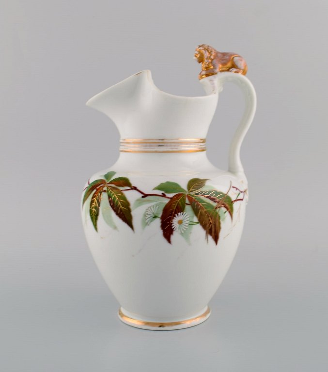 Antique Bing & Grøndahl chocolate jug in porcelain modeled with a lion on the handle. Hand-painted flowers and gold decoration. 1870s.