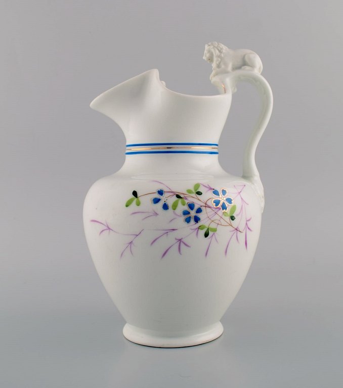 Antique Bing & Grøndahl chocolate jug in porcelain modeled with a lion on the handle. Hand-painted flowers and gold decoration. 1870s.