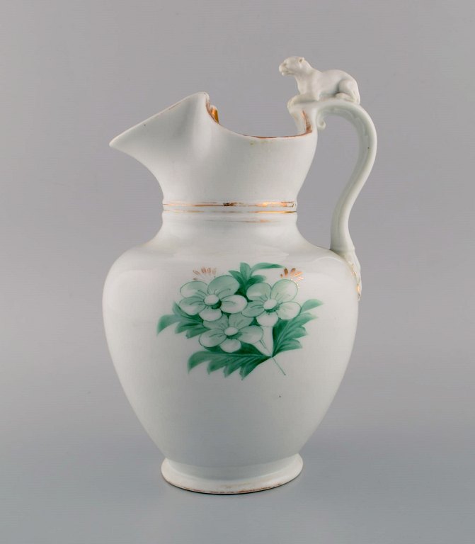 Antique Bing & Grøndahl chocolate jug in porcelain modeled with a lion on the handle. Hand-painted flowers and gold decoration. 1870s.