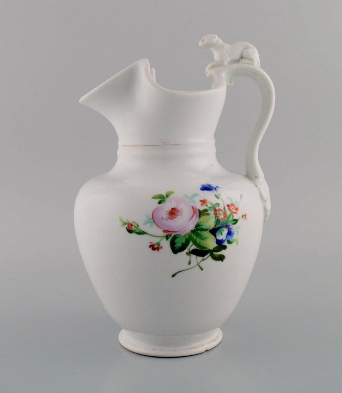 Antique Bing & Grøndahl chocolate jug in porcelain modeled with a lion on the handle. Hand-painted flowers and gold decoration. 1870s.
