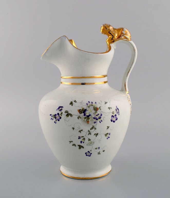 Antik Gustafsberg chokoladekande i porcelæn modeleret med løve på hanken. Håndmalede blomster og gulddekoration. Sent 1800-tallet.