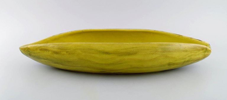 St. Clement, France. Colossal organically shaped bowl in hand-painted glazed stoneware. Beautiful glaze in yellow shades. Mid-20th century.