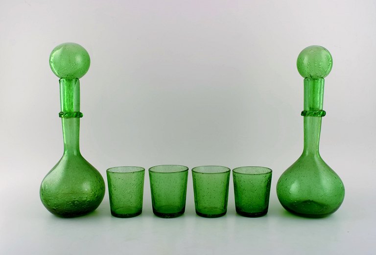 Biot, Frankrig. To vinkarafler og fire glas i grønt mundblæst kunstglas med indlagte bobler. Midt 1900-tallet.