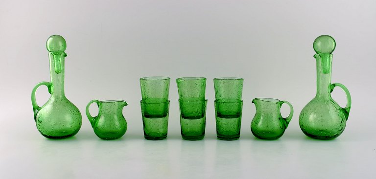 Biot, Frankrig. To karafler, seks glas og to små kander i grønt mundblæst kunstglas med indlagte bobler. Midt 1900-tallet.