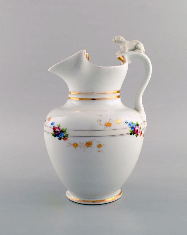 Antique Bing & Grøndahl chocolate jug in porcelain modeled with a lion on the handle. Hand-painted flowers and gold decoration. 1870s.