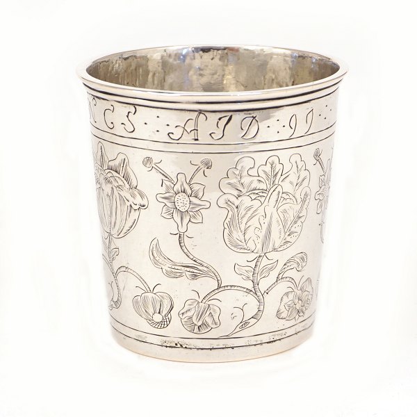 Sølvbæger. Lille kraftigt sølvbæger prydet med stiliserede blomster og navnetræk med datering 1699. Danmark. Sandsynligvis bryllupsbæger. H: 7,1cm. V: 103gr