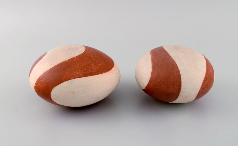 European studio ceramicist. Two rattle instruments in glazed stoneware. Hand-painted wavy decoration in orange-brown shades. Late 20th century.