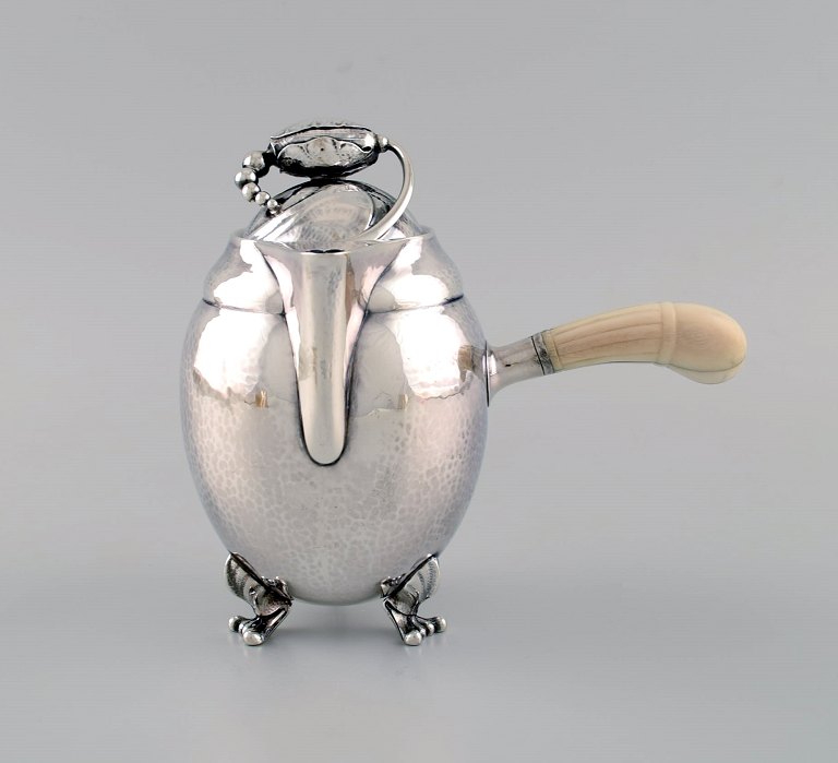 Georg Jensen Magnolia chokoladekande i hammerslået sterlingsølv med hank af elfenben. Model 2A. Dateret 1915-1930.