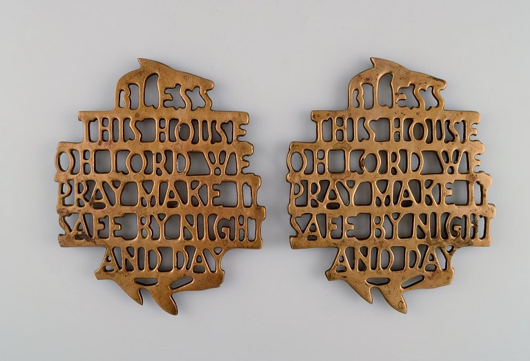 Estrid Ericson for Svenskt Tenn, Stockholm. To "Bless this house" bordskånere i messing. Midt 1900-tallet.