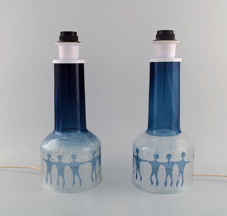 Ove Sandberg for Kosta Boda. To bordlamper i blåt og klart kunstglas dekoreret med personer. 1970