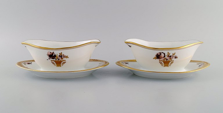 Two Royal Copenhagen Golden Basket sauce bowls in porcelain with flowers and gold decoration. Model number 595/9344. Early 20th century.