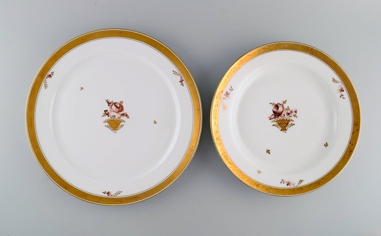 Two round Royal Copenhagen Golden Basket serving dishes in porcelain with flowers and gold decoration. Early 20th century.