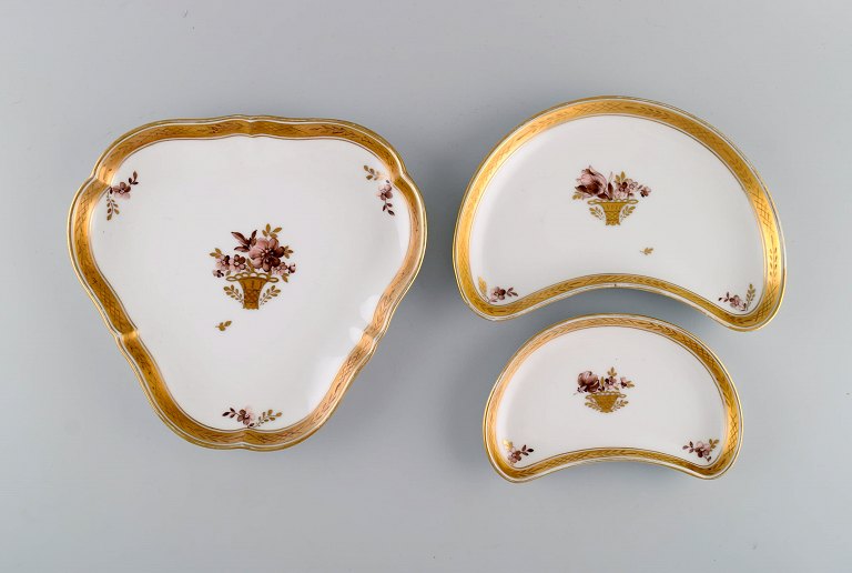 Three Royal Copenhagen Golden Basket dishes in porcelain with flowers and gold decoration. Early 20th century.