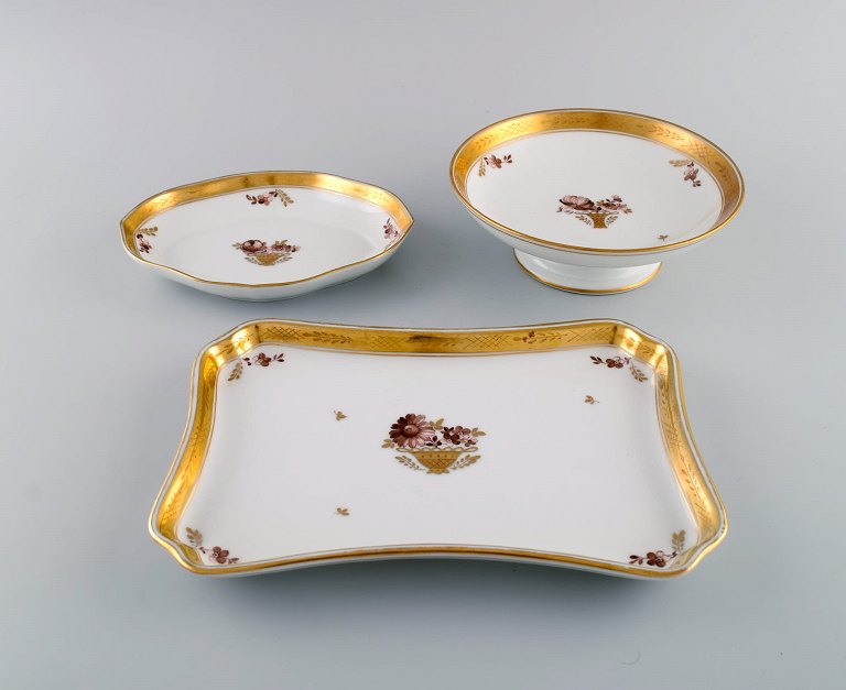 Three Royal Copenhagen Golden Basket dishes in porcelain with flowers and gold decoration. Early 20th century.