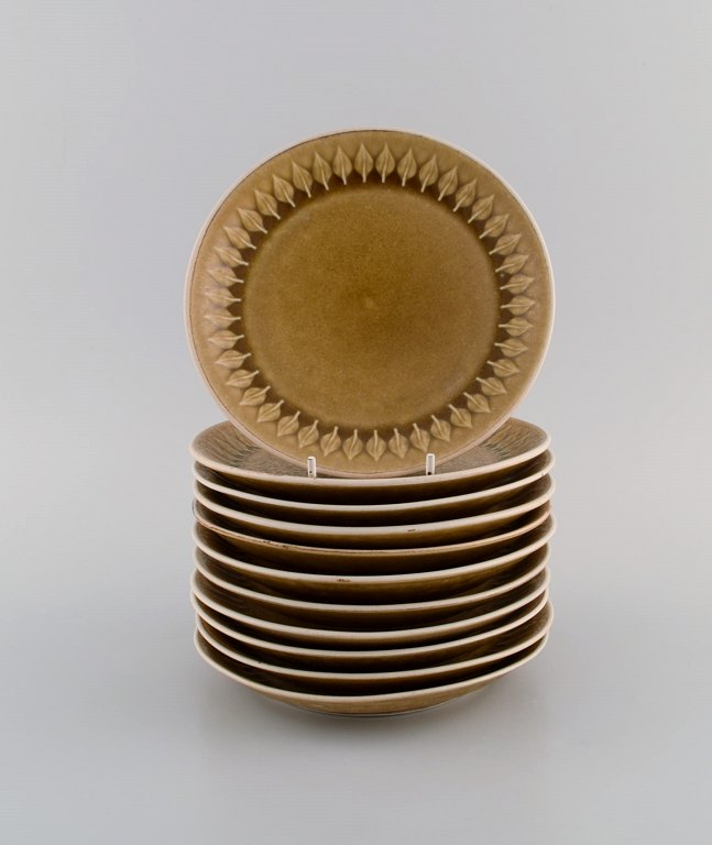 Jens H. Quistgaard (1919-2008) for Bing & Grøndahl / Nissen Kronjyden. 11 Relief kagetallerkener i glaseret stentøj. Smuk glasur i sennepsgule nuancer. 1960