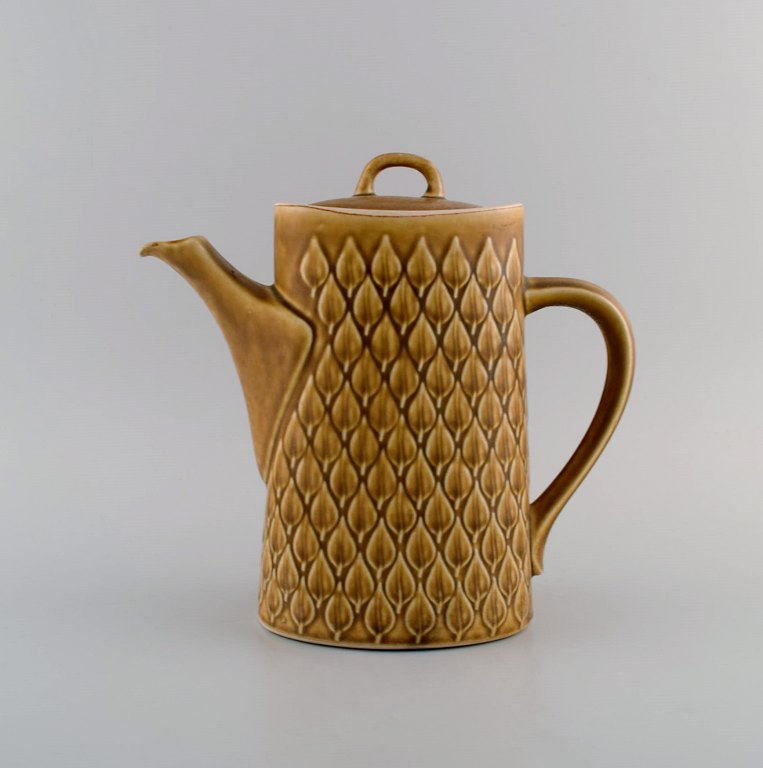 Jens H. Quistgaard (1919-2008) for Bing & Grøndahl / Nissen Kronjyden. Relief kaffekande i glaseret stentøj. Smuk glasur i sennepsgule nuancer. 1960