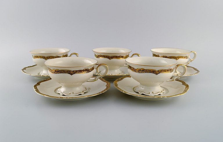 KPM, Berlin. Fem Royal Ivory tekopper med underkopper i cremefarvet porcelæn med gulddekoration. 1920