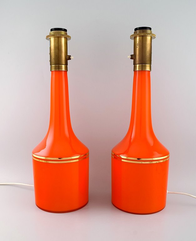 Anders Pehrson for Ateljé Lyktan. To store bordlamper i orange mundblæst kunstglas med gulddekoration. 1960