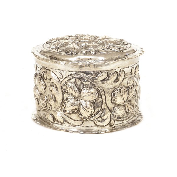 Rund sølvdåse med låg med drevne dekorationer i form af stiliseret bladværk. Thore Sørensen, Aalborg, 1701-32. God stand. Fodrand med lille skade. H: 6cm. D: 8,3cm