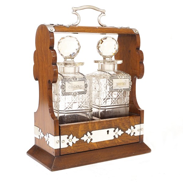 Tantalus in an oak box with two decanters. England circa 1880. H: 33cm. W: 25cm. D: 14cm