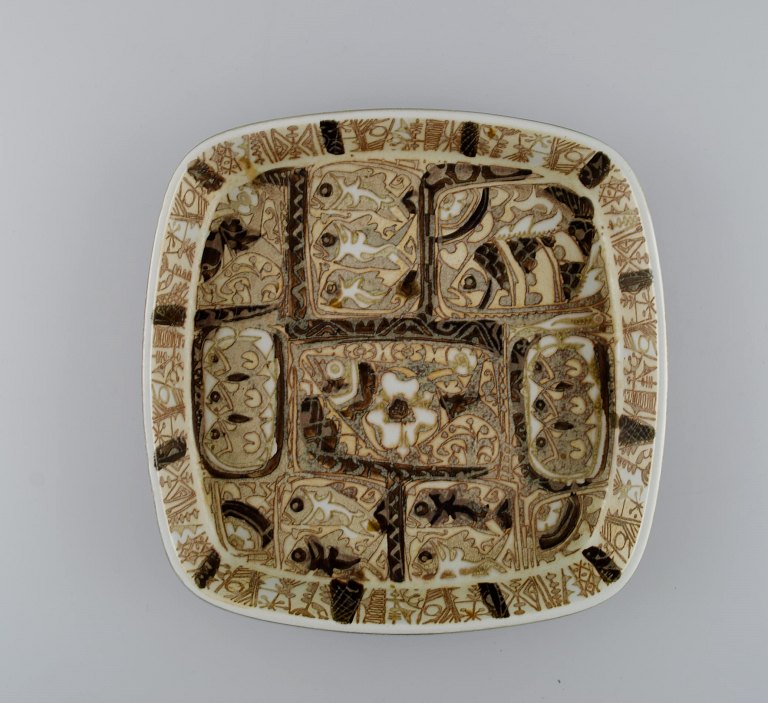 Nils Thorsson and Johanne Gerber for Aluminia, Royal Copenhagen. Square Baca dish decorated with fish, patterned glaze in sand and light brown shades. 1960/70s.