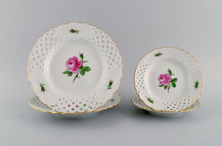 Four Meissen Pink Rose plates in openwork porcelain with hand-painted roses and gold edge. Early 20th century.