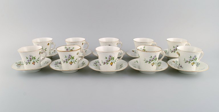 10 Rörstrand coffee cups with saucers in hand-painted porcelain. Flowers, gold edge and foliage in relief. Approx. 1900.