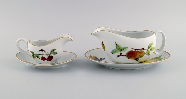Royal Worcester, England. Two Evesham sauce jugs with saucers in porcelain decorated with fruits and gold rim. 1980s.