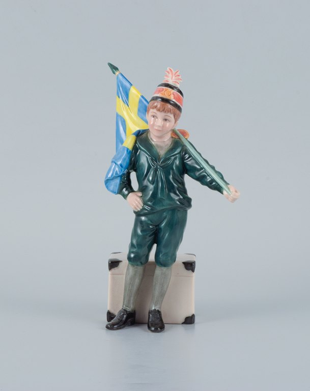 Carl Larsson Pontus for Royal Copenhagen, håndmalet porcelænsfigur i overglasur, svensk fanebærer-dreng i grønne klæder.