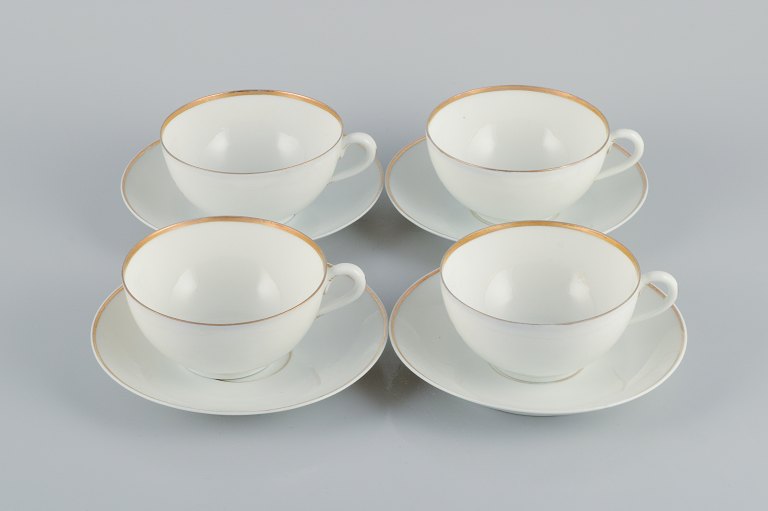 Rosenthal, Tyskland, et sæt på fire store tekopper med tilhørende underkopper i porcelæn. Tyndt hvidt porcelæn med gulddekoration.