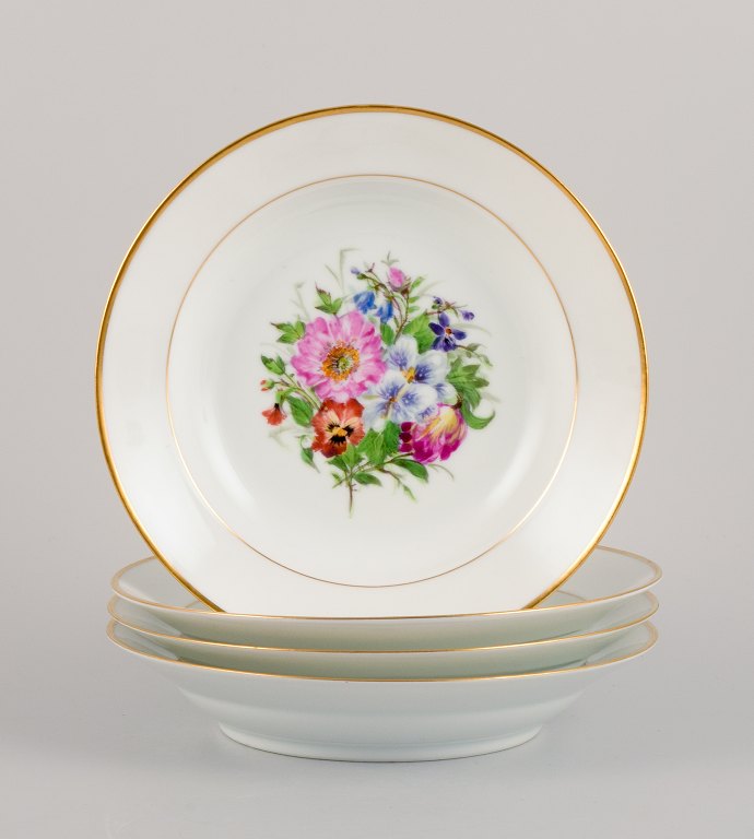 Bing & Grøndahl, four deep plates in porcelain hand-painted with polychrome flowers and gold decoration.