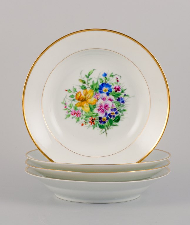 Bing & Grøndahl, four deep plates in porcelain hand-painted with polychrome flowers and gold decoration.