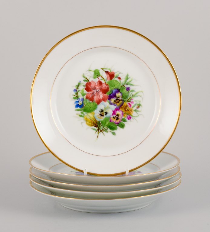 Bing & Grøndahl, five porcelain lunch plates hand-painted with polychrome flowers and gold decoration.
