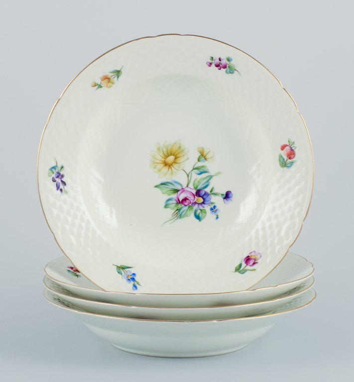 Bing & Grøndahl, Saxon Flower, a set of four deep plates hand-decorated with polychrome flowers and gold rim.