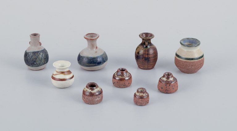Stouby Keramik, Danmark, en samling på ni miniature keramikvaser med glasur i brune og sandfarvet toner.