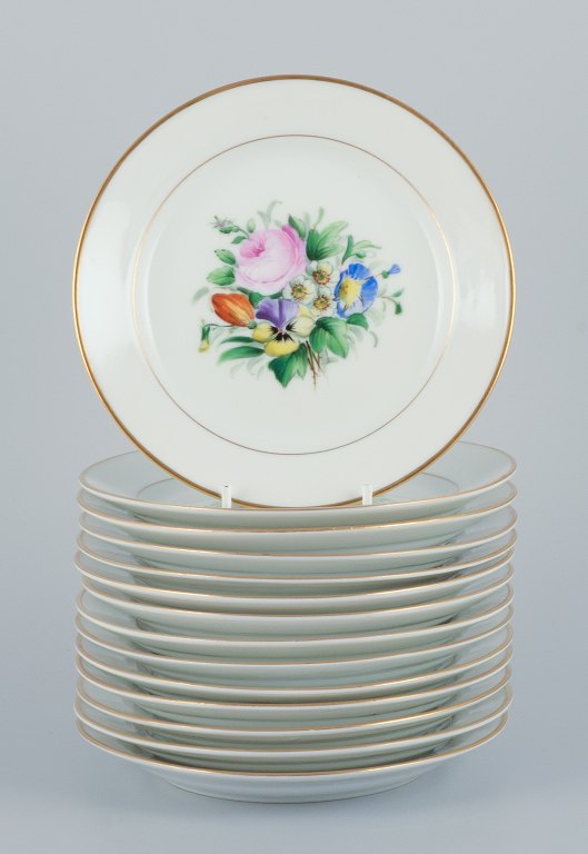 Bing & Grondahl, a set of fourteen plates hand-painted with various polychrome flower motifs and gold trim.
