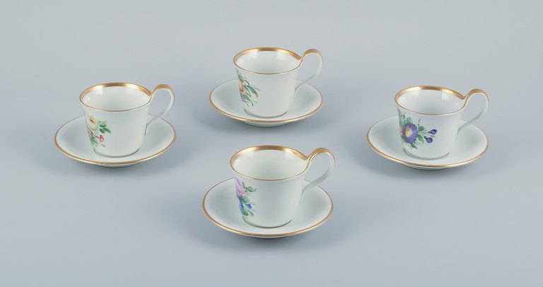 Bing & Grøndahl, a set of four antique coffee cups with high handles and  saucers. Hand-painted with polychrome flower decoration. Porcelain of strong quality.