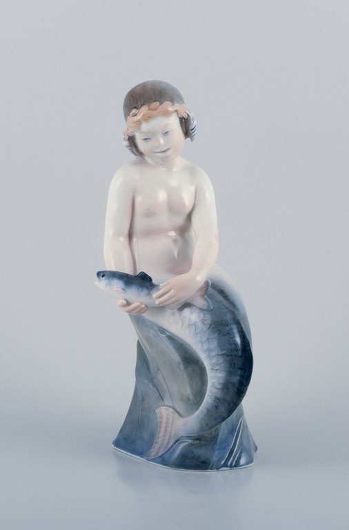 Royal Copenhagen, rare porcelain figurine of a mermaid holding fish in her hands.