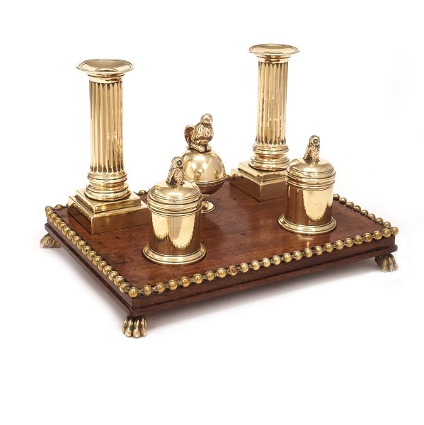 Writing set on a mahogany base with a pair of brass candlesticks, small sand- and ink containers and a bell. Circa 1780. Base: 19x25,5cm. H: 17cm