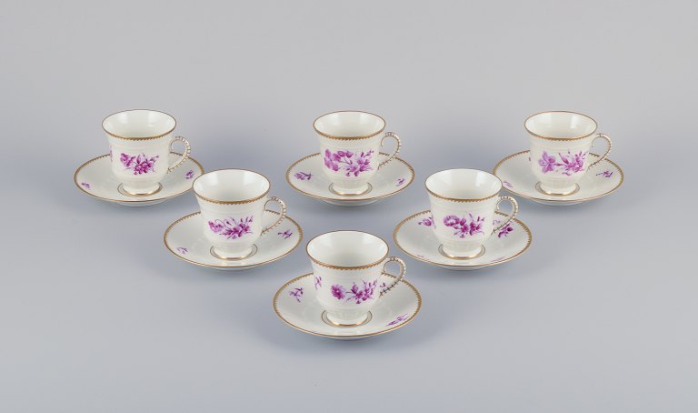 Bing & Grøndahl, Danmark. Et sæt på seks kaffekopper og underkopper med blomsterdekorationer i purpur og guldkant. Håndmalet.