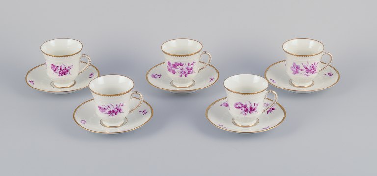 Bing & Grøndahl, Danmark. Et sæt på fem kaffekopper og underkopper med blomsterdekorationer i purpur og guldkant. Håndmalet.